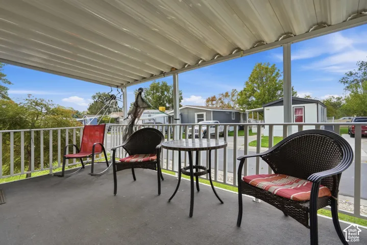 Covered outdoor patio with a white railing and a concrete surface
