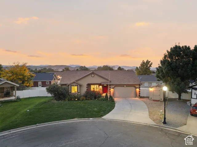Single-story residence featuring a concrete driveway, attached garage, and a peaked roof