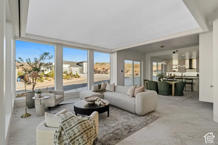 Expansive floor-to-ceiling windows, recessed lighting, tile flooring, and a kitchen featuring a range hood and pendant lighting
