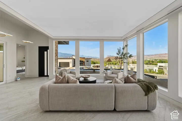 Expansive multi-panel windows, high ceilings, recessed lighting, and light-toned tile flooring