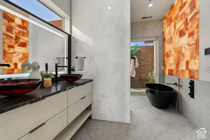 Dual vessel sinks set on a dark countertop with a built-in vanity