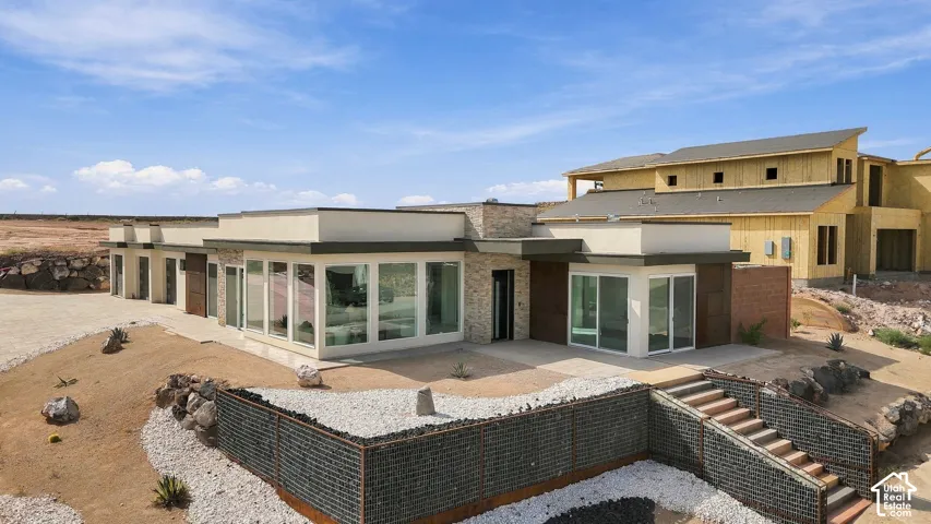 Modern architectural design featuring expansive window walls, a flat roofline, and stone accents