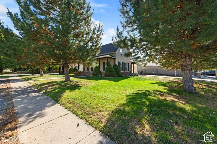 Exterior featuring a covered porch, stone accent siding, and dark window shutters