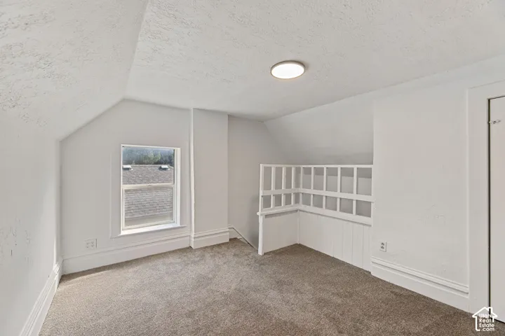 Main House Upstairs Loft Area with New Carpeted room with sloped ceilings, a single window, recessed lighting, and a built-in white railing feature