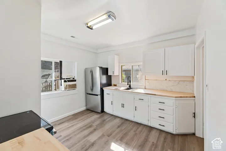 ADU Kitchen featuring white cabinetry, wood-finish countertops, stainless steel appliances, and wood-finish flooring