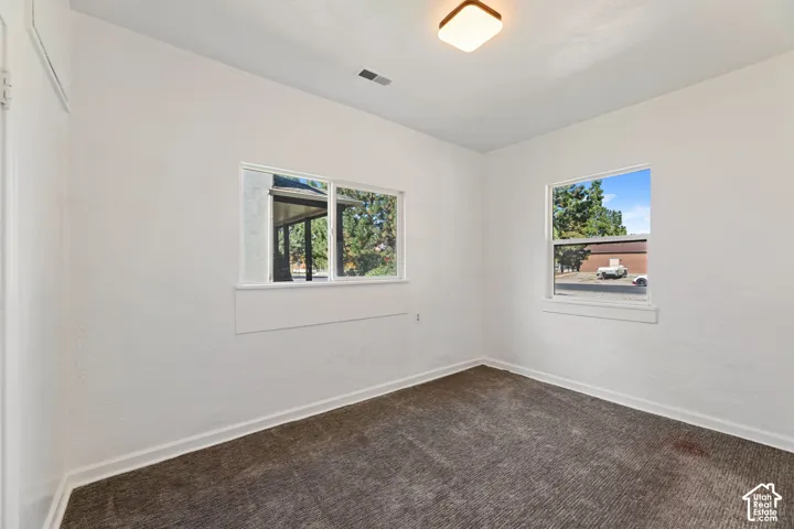 ADU 1 Bedroom with Bright interior with textured carpeting, two windows, and overhead lighting