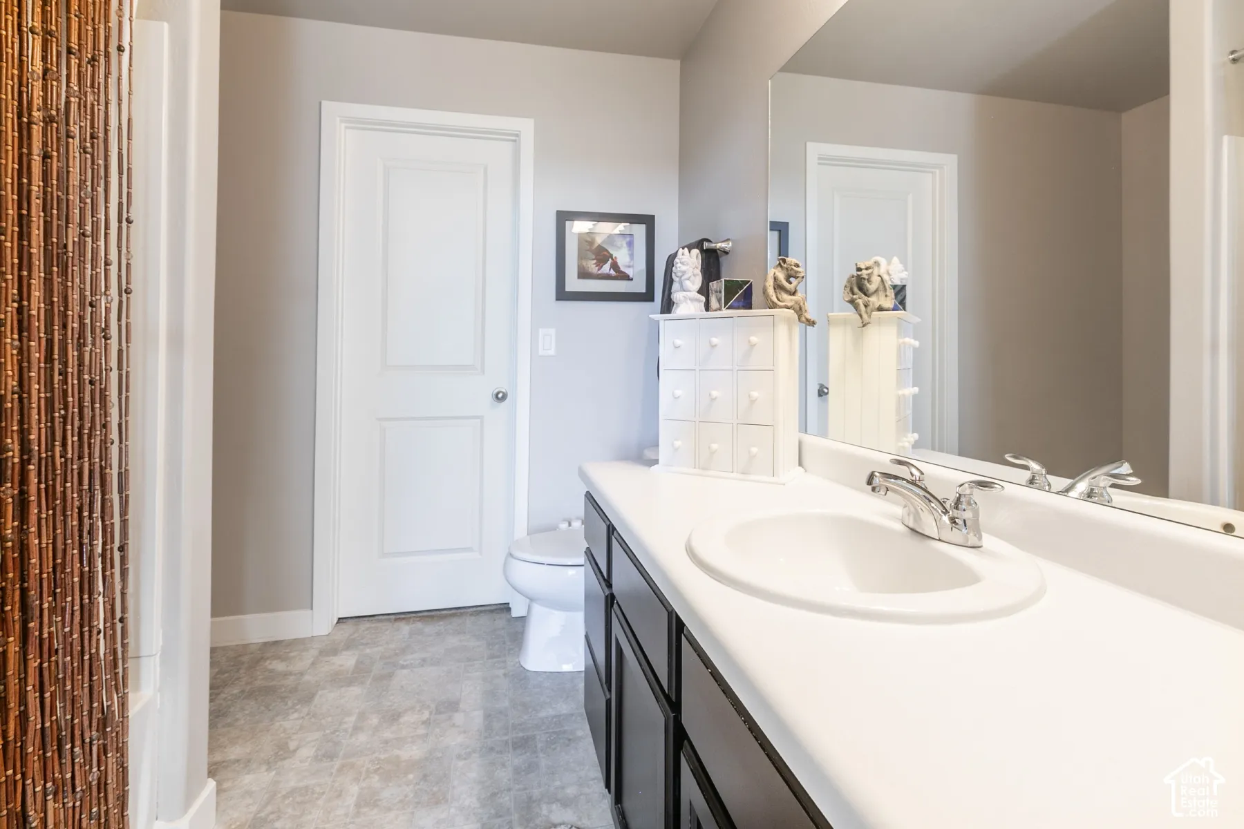Vanity with an integrated white sink, chrome faucet, and expansive mirror