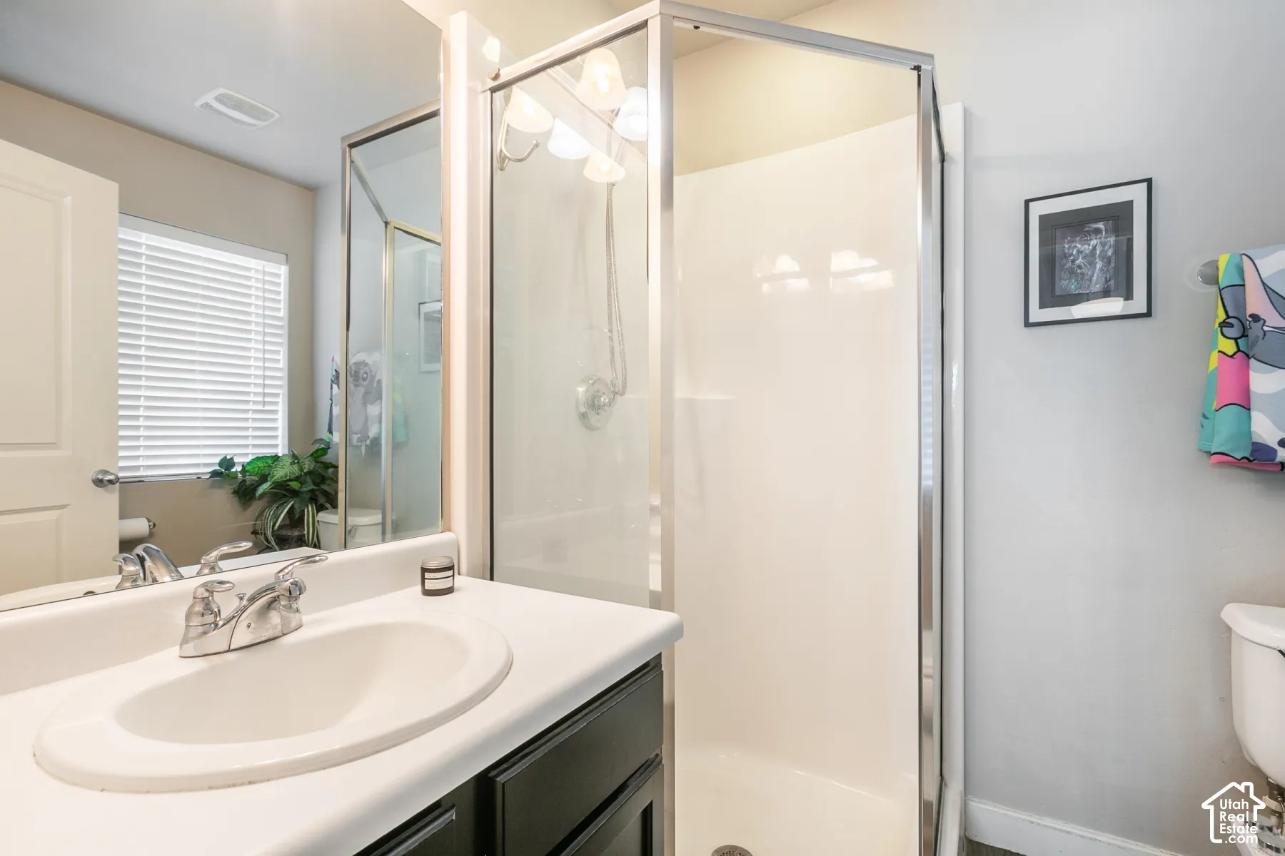 Vanity with integrated sink, chrome faucet, and dark wood-finish cabinetry
