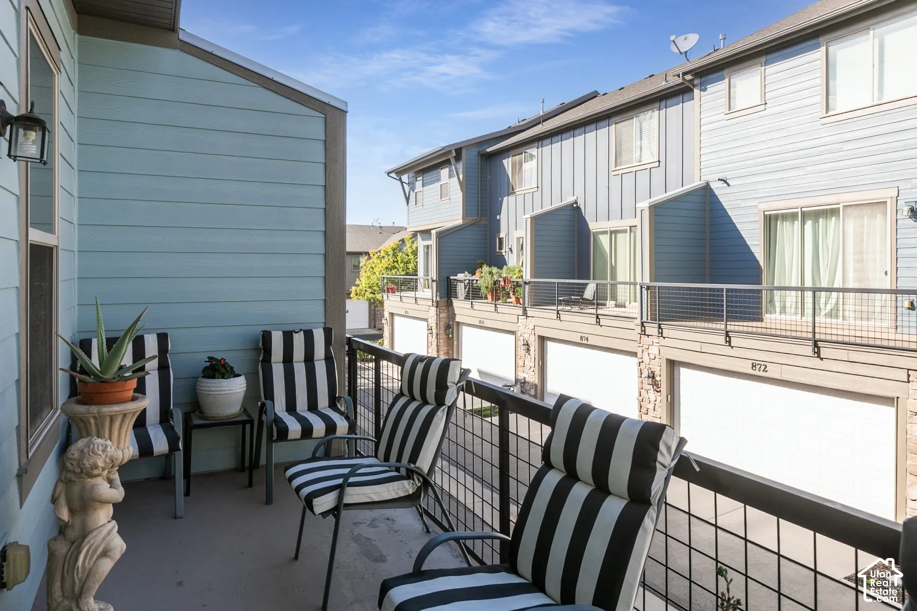 Balcony with a black metal railing and blue horizontal siding