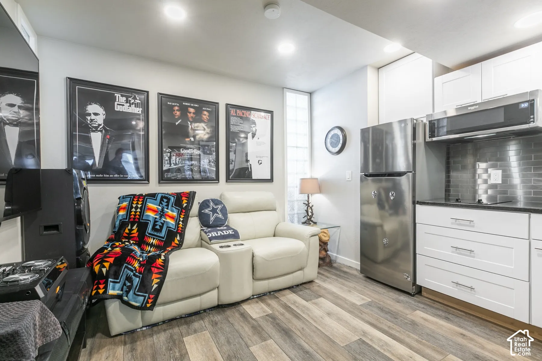 Compact kitchen area featuring stainless steel appliances, white cabinetry, and a tile backsplash