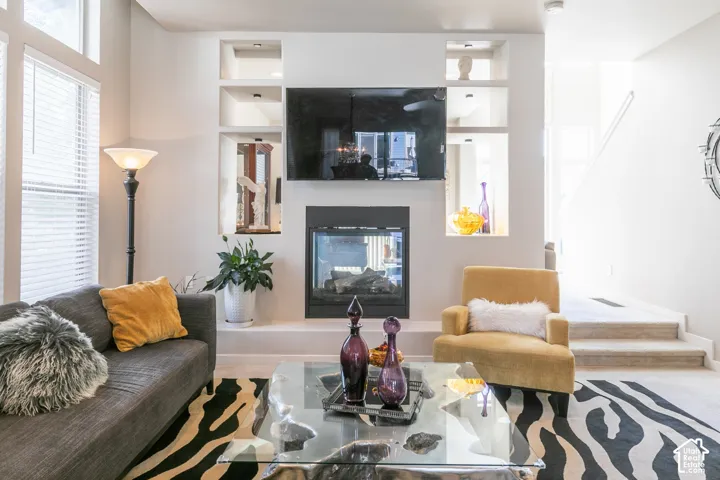 Recessed wall niches with accent lighting, built-in fireplace, and large windows with blinds