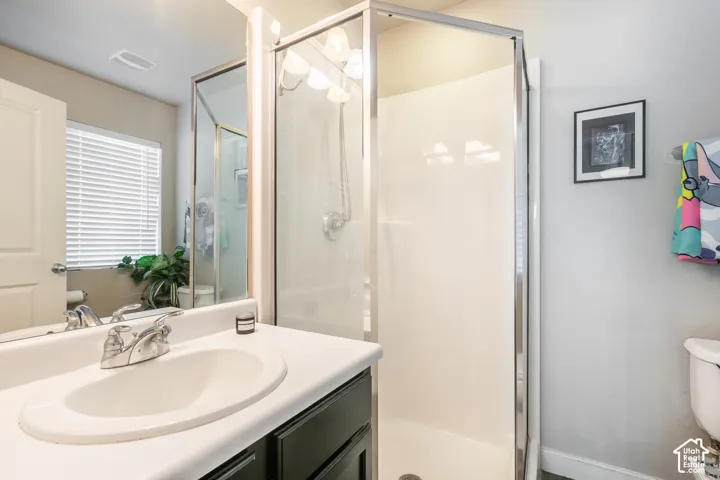 Vanity with integrated sink, chrome faucet, and dark wood-finish cabinetry