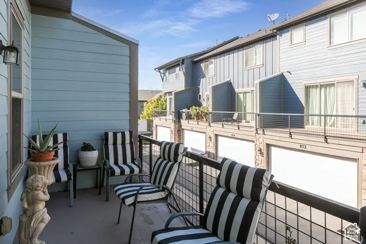 Balcony with a black metal railing and blue horizontal siding