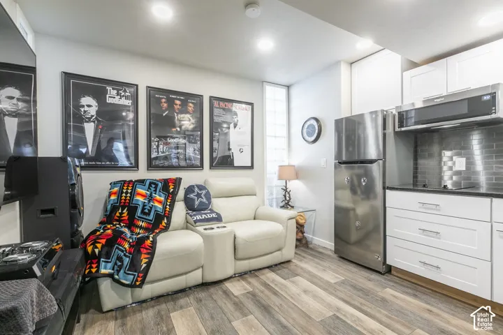 Compact kitchen area featuring stainless steel appliances, white cabinetry, and a tile backsplash