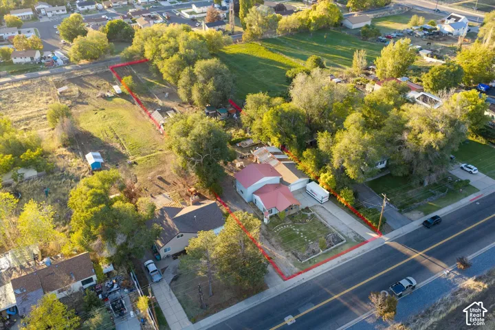 Aerial perspective of a property featuring an expansive one-acre lot with mature trees.