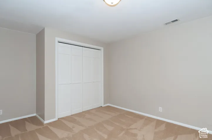Recessed lighting, neutral wall paint, bi-fold closet doors, and carpet flooring