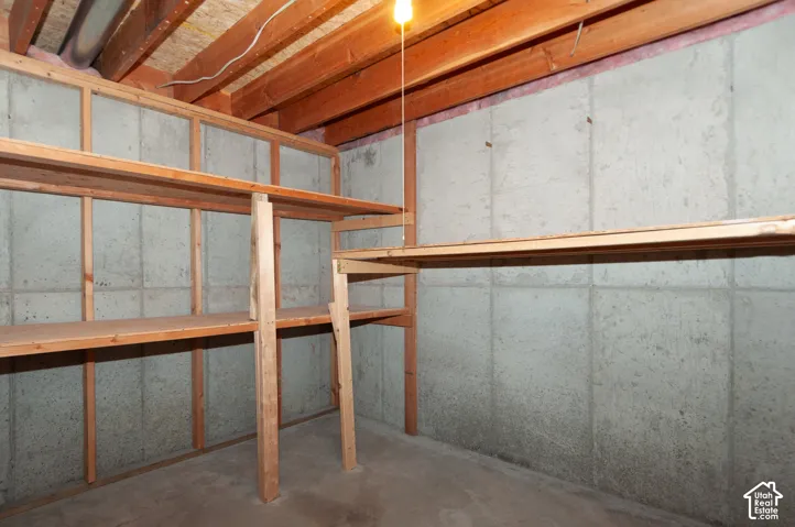 Built-in wood shelving units, exposed wood ceiling joists, and concrete walls
