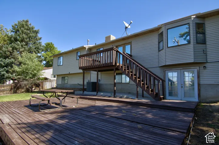 Expansive wood-finish deck with integrated stairs, multiple windows, and a bay window