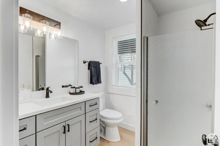 Vanity with shaker-style cabinetry, white countertop, and dark hardware