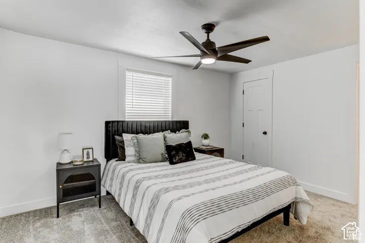 Recessed window with blinds, white paneled door, ceiling fan with integrated lighting, and neutral-toned carpeting