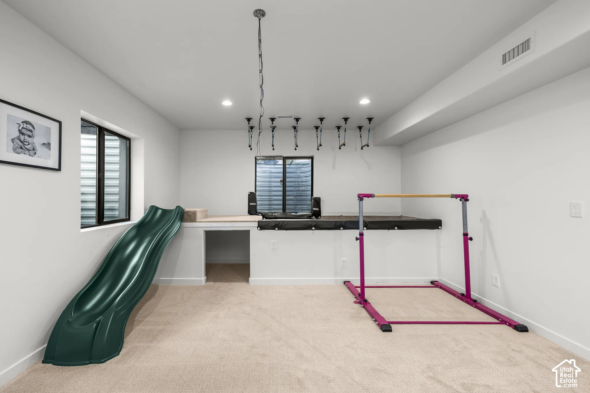 Recessed lighting, light-toned carpeting, a built-in platform, and white walls