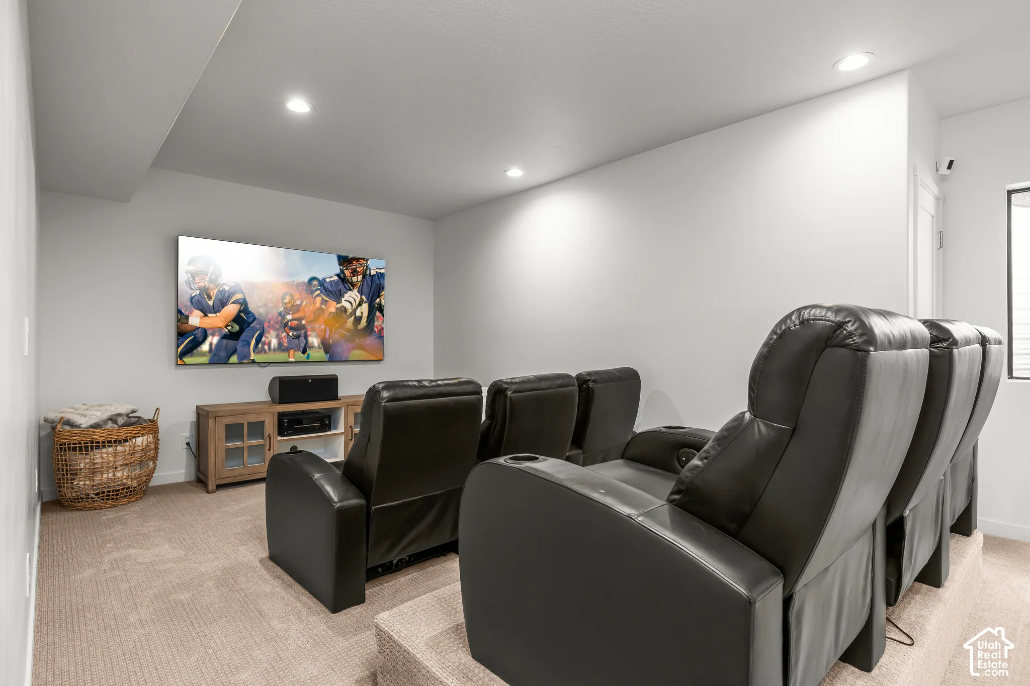 Entertainment room featuring a large wall-mounted screen, recessed lighting, and carpeting