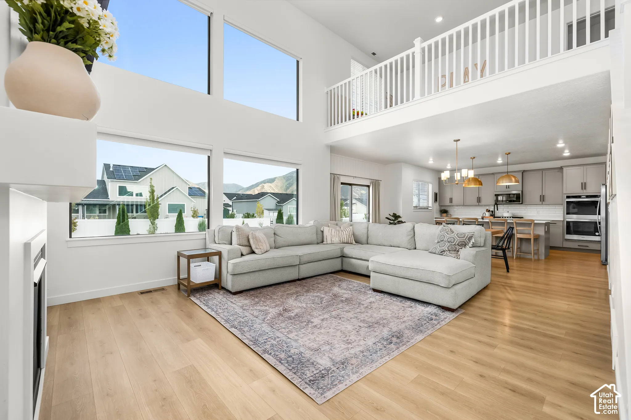 Expansive living space featuring high ceilings, wood-finish flooring, and multiple windows