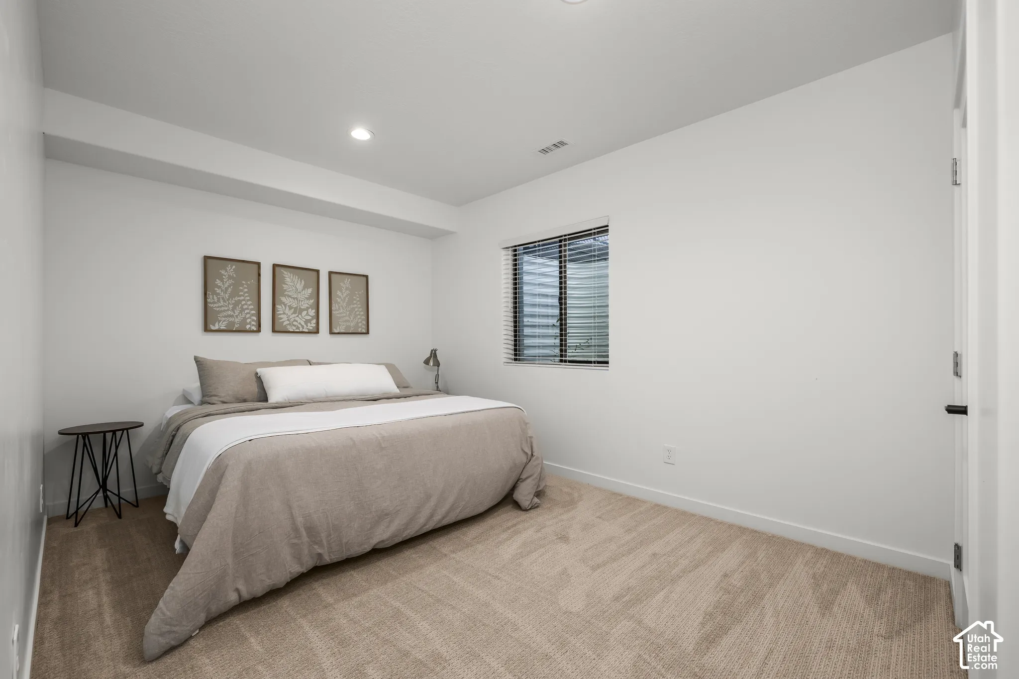 Recessed lighting, light-colored carpeting, white interior walls, and a window with blinds