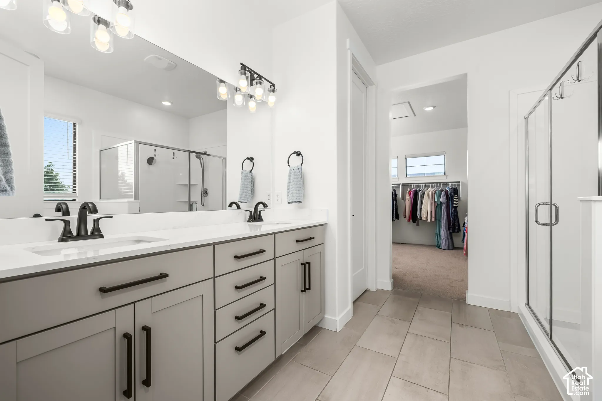 Dual vanity with white countertops, matte black fixtures, and light gray cabinetry
