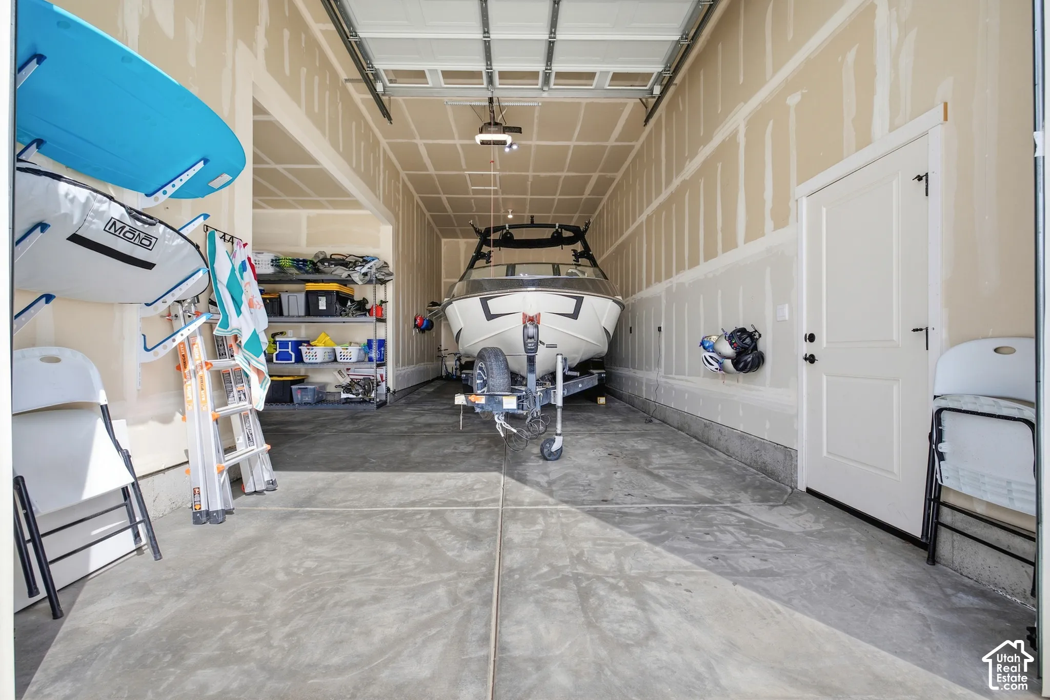 Spacious garage with exposed framing, concrete flooring, and an interior access door