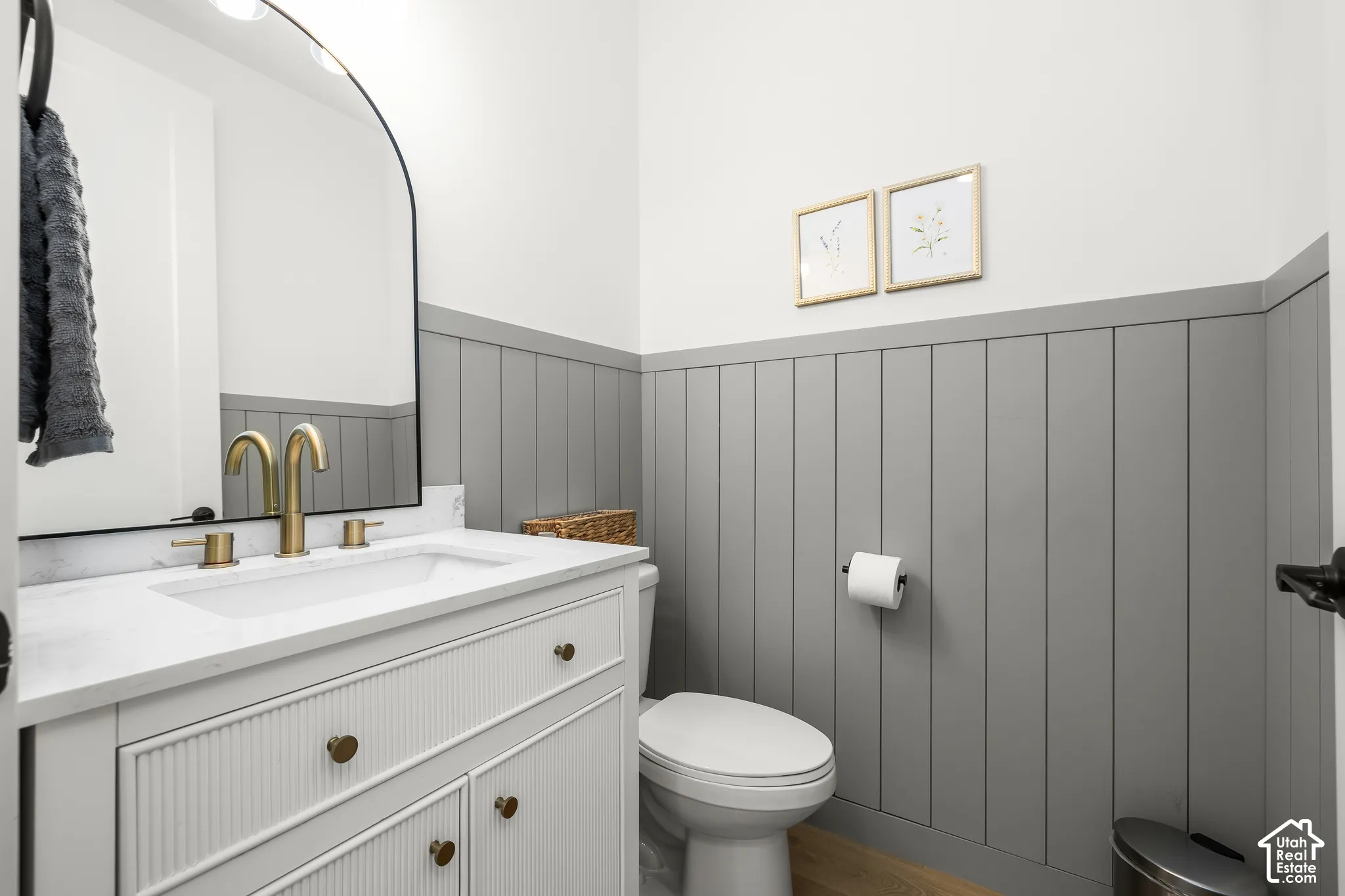 Vanity with integrated sink, gold-finish faucet, and arched mirror