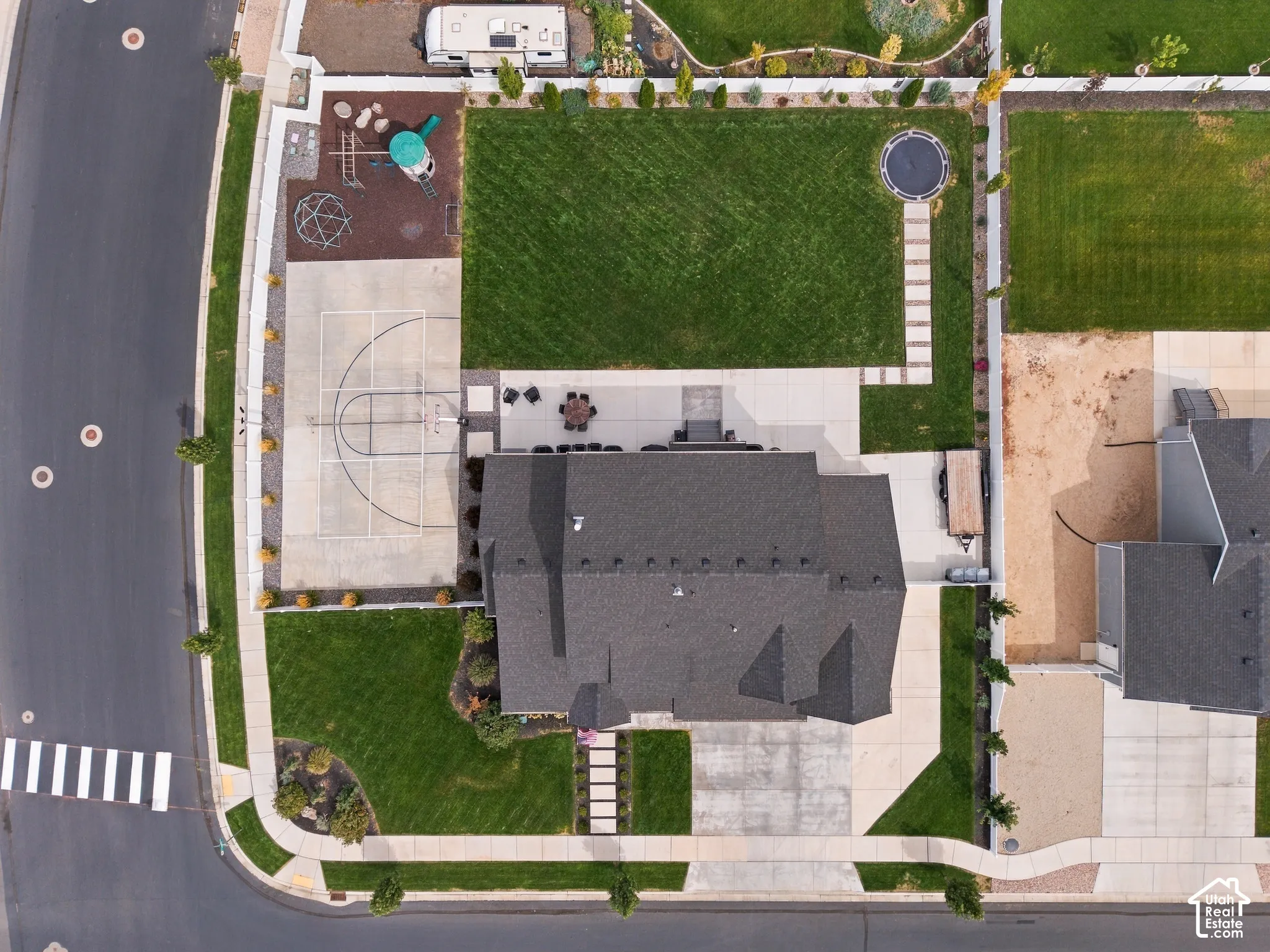 Expansive lot featuring a large lawn, dedicated sport court, concrete patio, and established landscaping