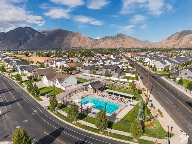 Mountain backdrop, neighborhood setting, community pool, multiple residential structures, paved roads