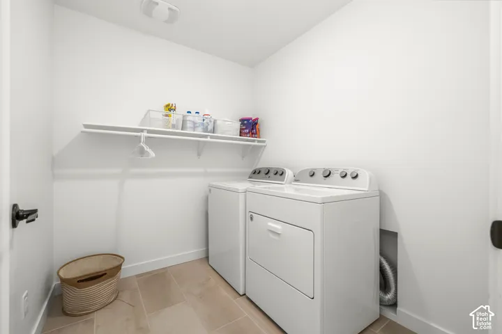 Laundry area featuring a built-in shelf, neutral wall tones, and tiled flooring
