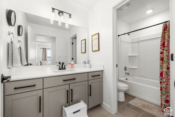 Bathroom featuring a single vanity with gray cabinetry, white countertop, and dark hardware