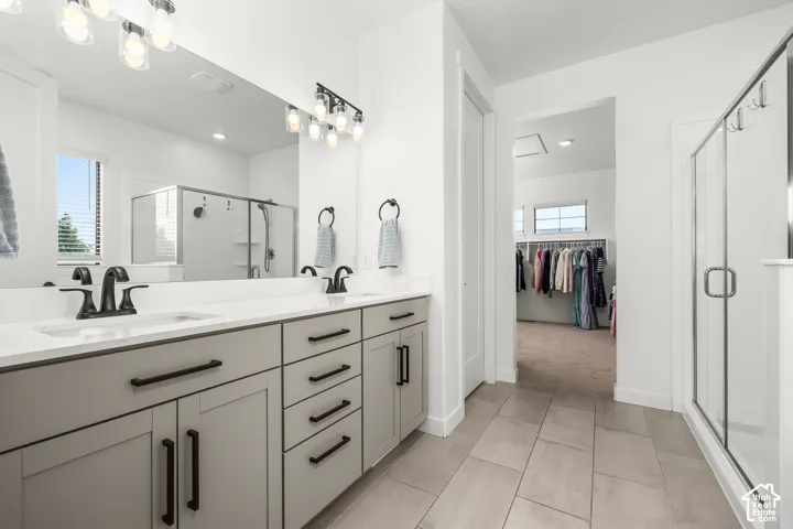 Dual vanity with white countertops, matte black fixtures, and light gray cabinetry
