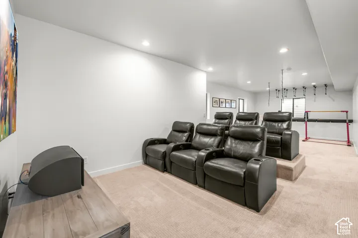 Built-in tiered seating with upholstered steps, recessed lighting, and carpet flooring