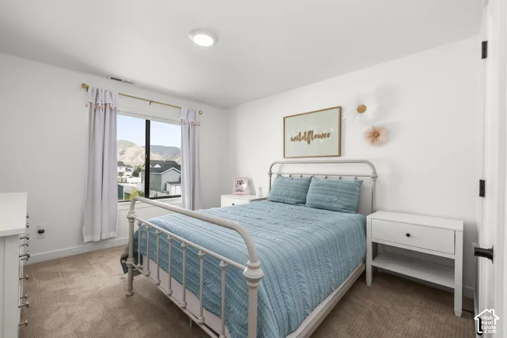 Recessed ceiling light, neutral wall color, window with mountain backdrop, and carpet flooring