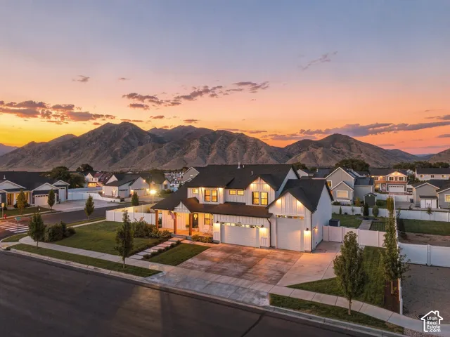 Modern farmhouse architectural style with a two-car garage, concrete driveway, and established landscaping