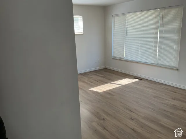 Wood-finish flooring throughout, bright white walls, and white horizontal blinds