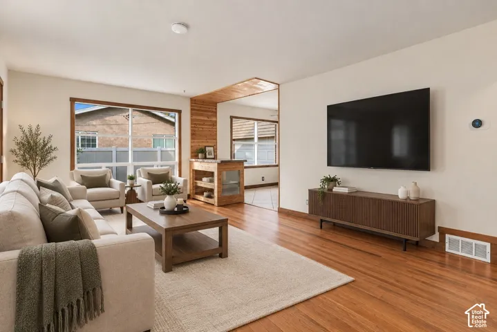 Hardwood flooring, recessed lighting, and large windows with wood trim