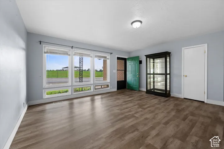 Living area featuring wood-finish flooring, a series of large windows, and a flush-mount ceiling light fixture