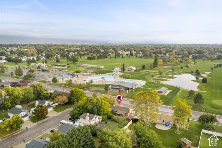 Aerial perspective featuring a residential lot with mature trees and a manicured lawn