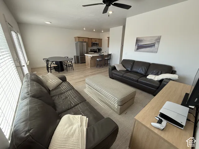 Open-concept living area featuring wood-finish flooring, recessed lighting, and a ceiling fan