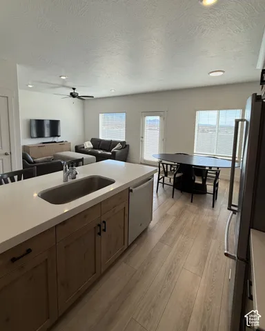 Kitchen island with a built-in sink, stainless steel faucet, and dishwasher