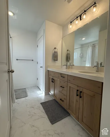 Dual vanity with light wood-finish cabinetry and matte black hardware