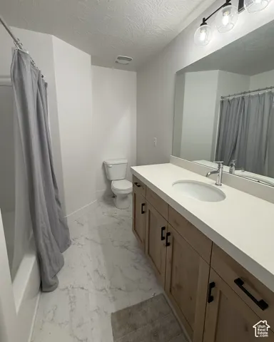 Contemporary bathroom with a light wood-finish vanity, white countertop, and an undermount sink