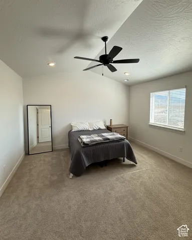 Vaulted ceiling with a black ceiling fan, recessed lighting, carpet flooring, and a window with horizontal blinds