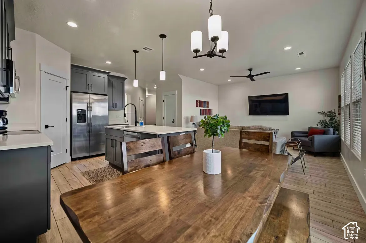 Open-concept living space with wood-finish flooring, recessed lighting, and a modern ceiling fan