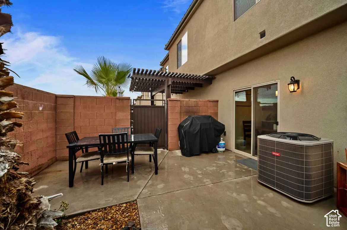 Private patio with concrete flooring, brick privacy walls, and sliding glass door access